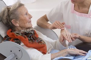 caregiver assists an elderly woman